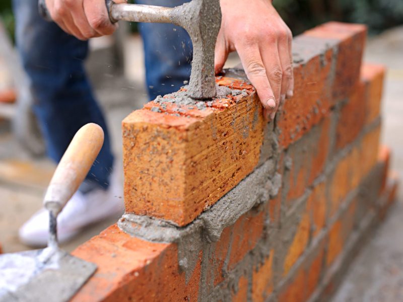 Laying the foundation one brick at a time. Shot of a master bricklayer at work